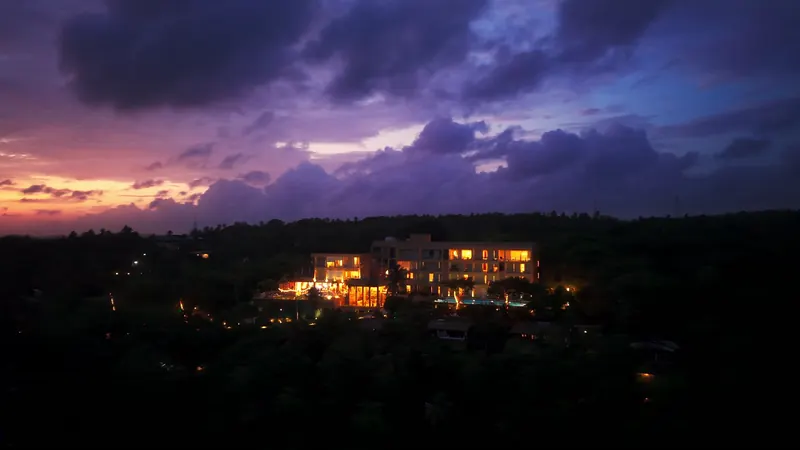 Elaya resort lit under purple storm clouds